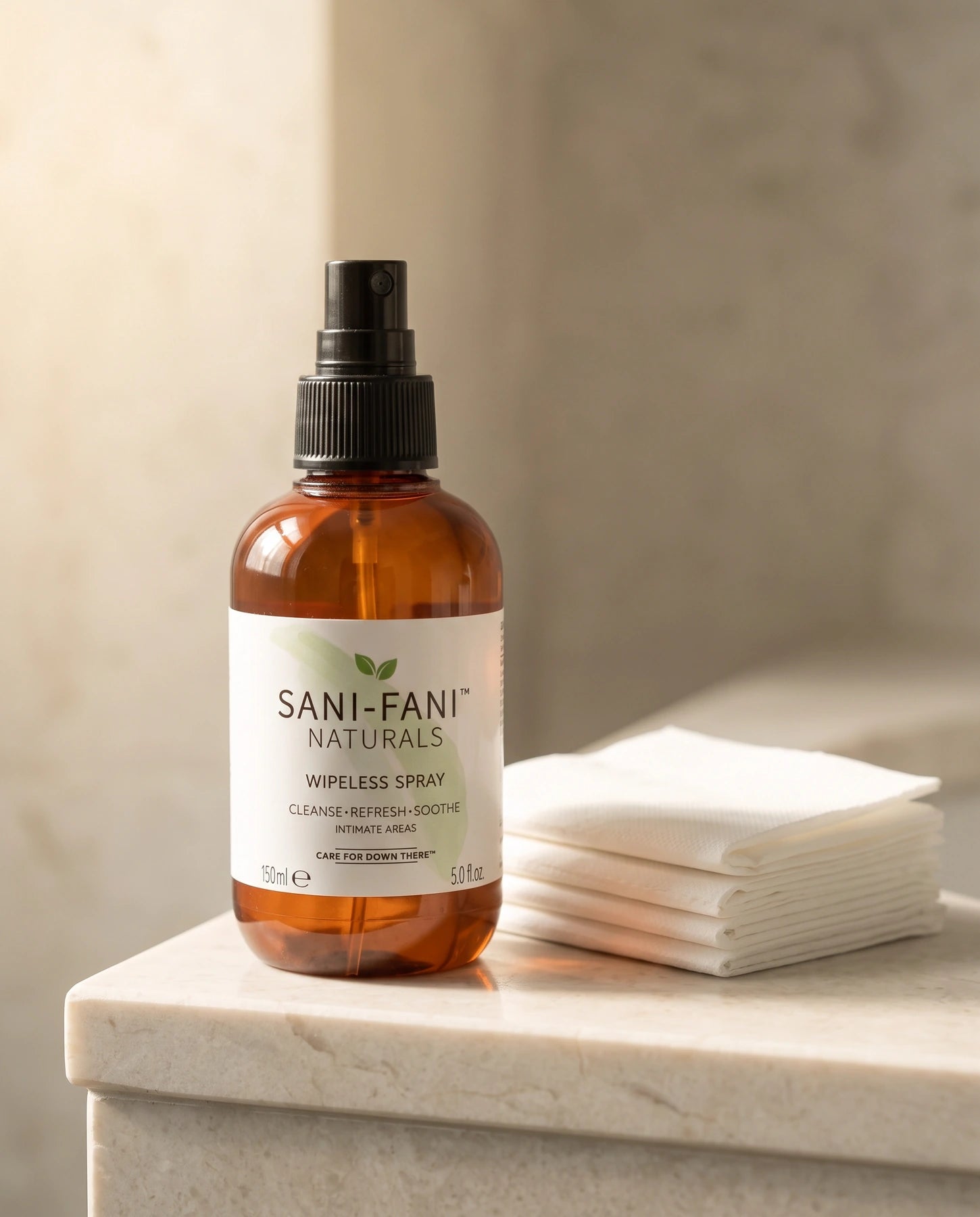 Sani-Fani spray beside folded toilet paper on a marble counter